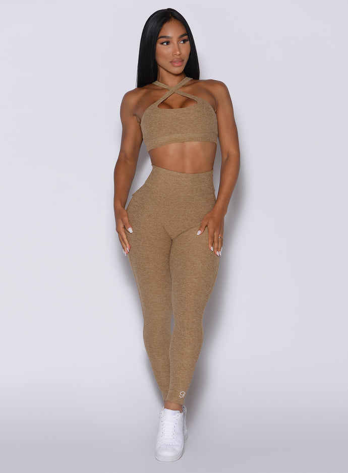 Front profile view of a model in our Pocket Pop Leggings in caramel color and a matching bra