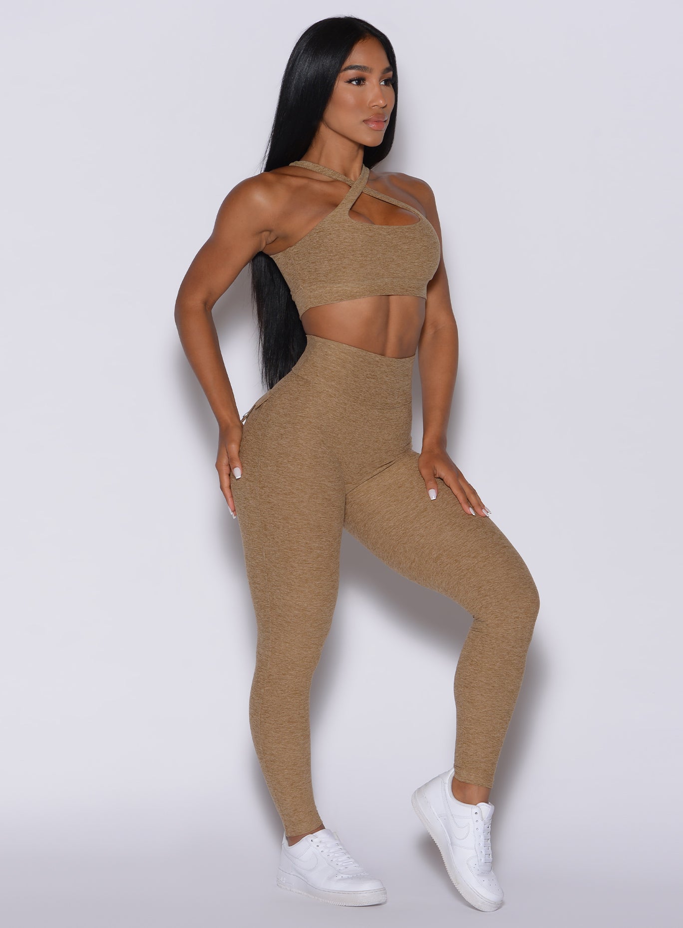 Left side profile view of a model in our Pocket Pop Leggings in caramel color and a matching bra