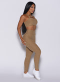 Left side profile view of a model in our Pocket Pop Leggings in caramel color and a matching two way bra