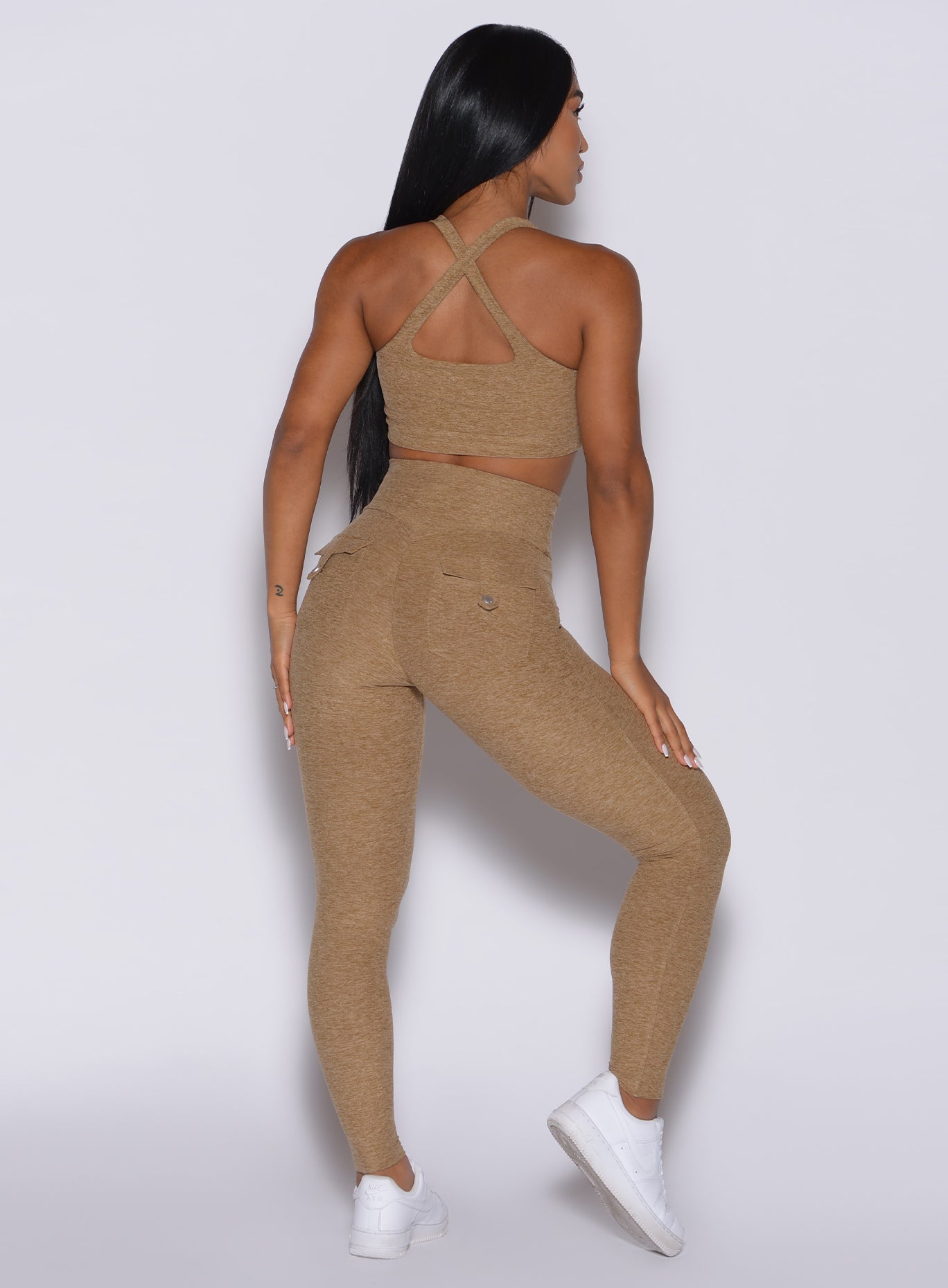 back profile view of a model in our Pocket Pop Leggings in caramel color and a matching sports bra