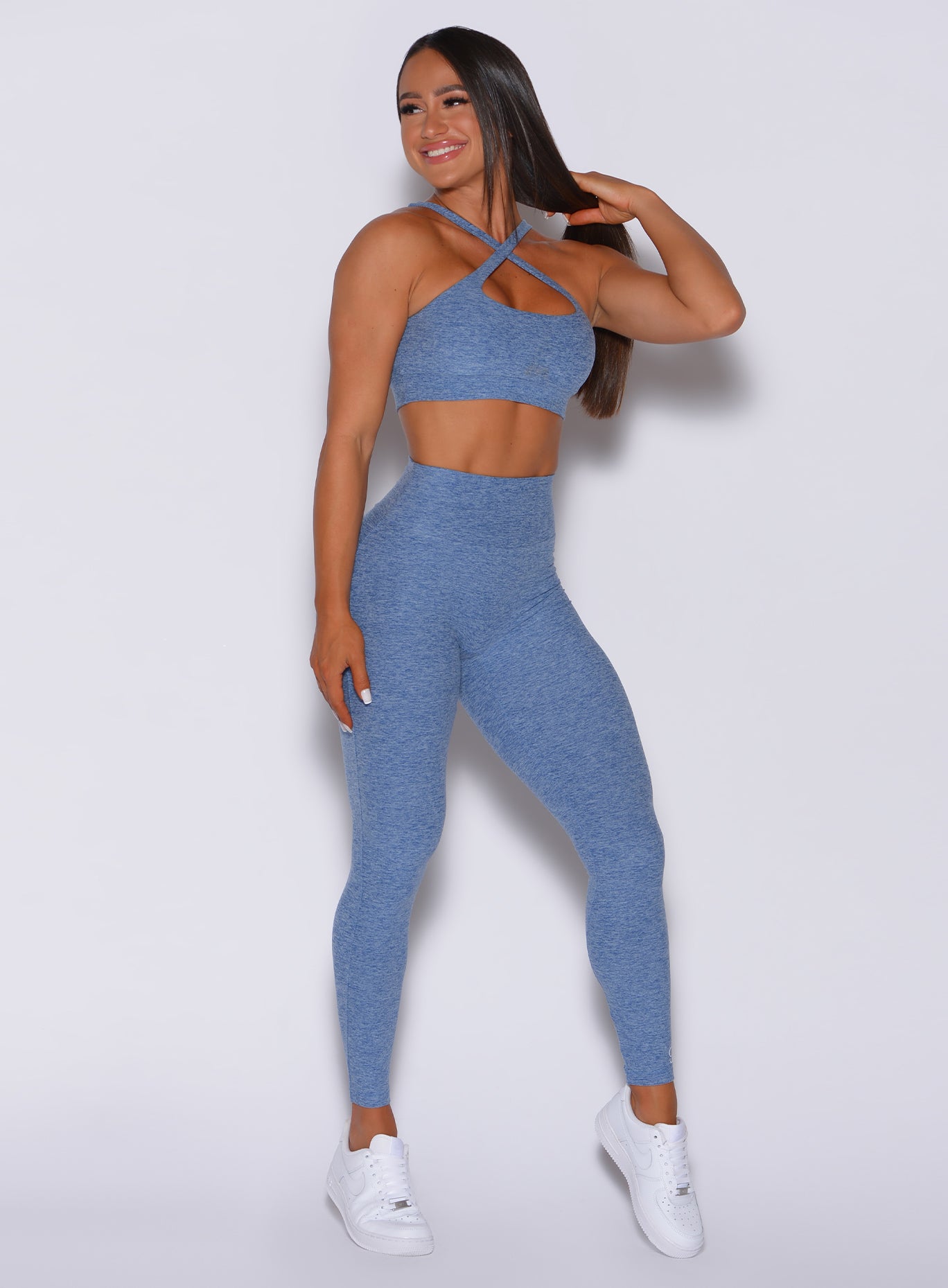 Front profile view of a model in our Pocket Pop Leggings in sky blue color and a matching two way sports bra