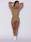 front profile view of a model in our Pocket Pop Shorts in caramel color and a matching sports bra 