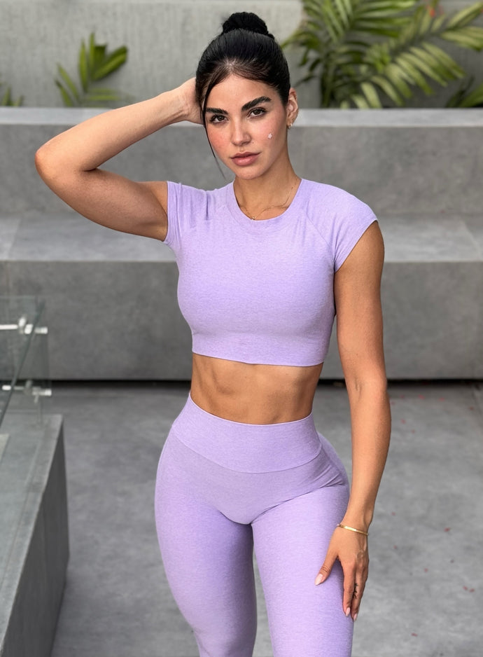 front profile view of a model in outdoors wearing the Core Strength Tee in Sugared Lilac color paired with the matching leggings