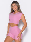 front profile view of a model with both hands on her thighs wearing the Core Strength Tee in Candy Pink color