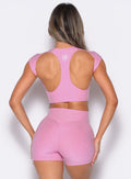 back profile view of a model wearing the Core Strength Tee in Candy Pink color