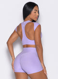 Back right side profile view of a model wearing the Core Strength Tee in Sugared Lilac color