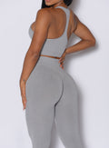 back profile of a model wearing the Lifter Heather Seamless Bra and the matching leggings in Silver Mist color