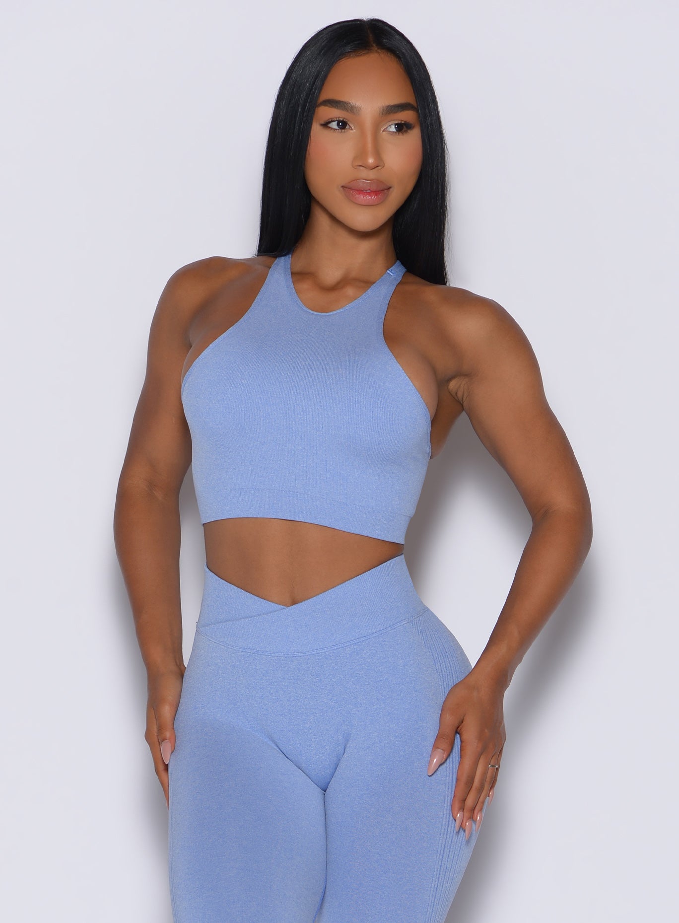 front profile view of a model wearing our Lifter Heather Seamless Bra and the matching leggings in Sky color