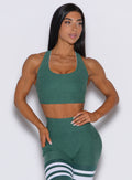 Front profile view of a model wearing our reversible tank bra in Emerald Green along with the matching leggings 