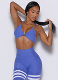 Front profile view of a model wearing our twist mini bra in violet blue color along with a matching thigh high leggings