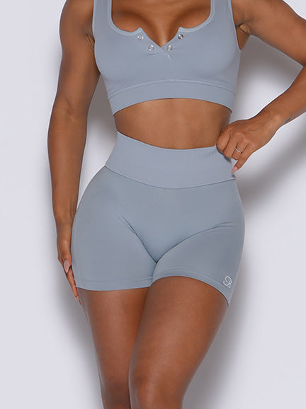 zoomed in front view of model wearing flawless figure scrunch shorts and snap front bra in gray