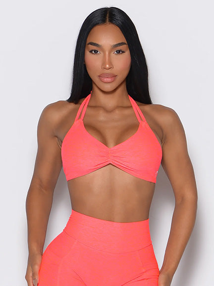 Zoomed in front view of model wearing a neon pink butterfly bra and leggings