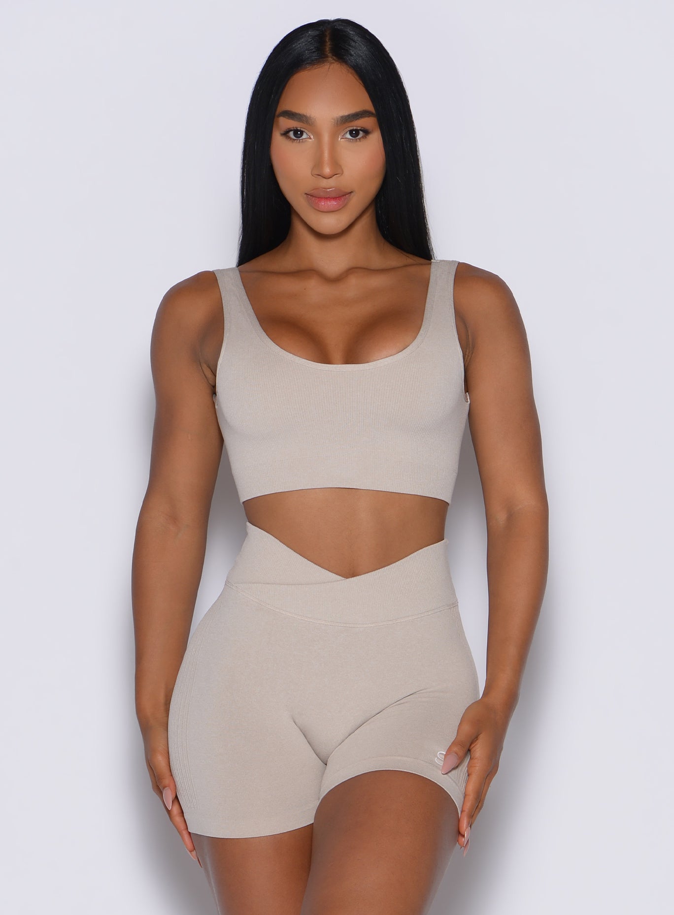 front profile view of a model wearing our Seamless Scoop Bra and the matching shorts in Oat color