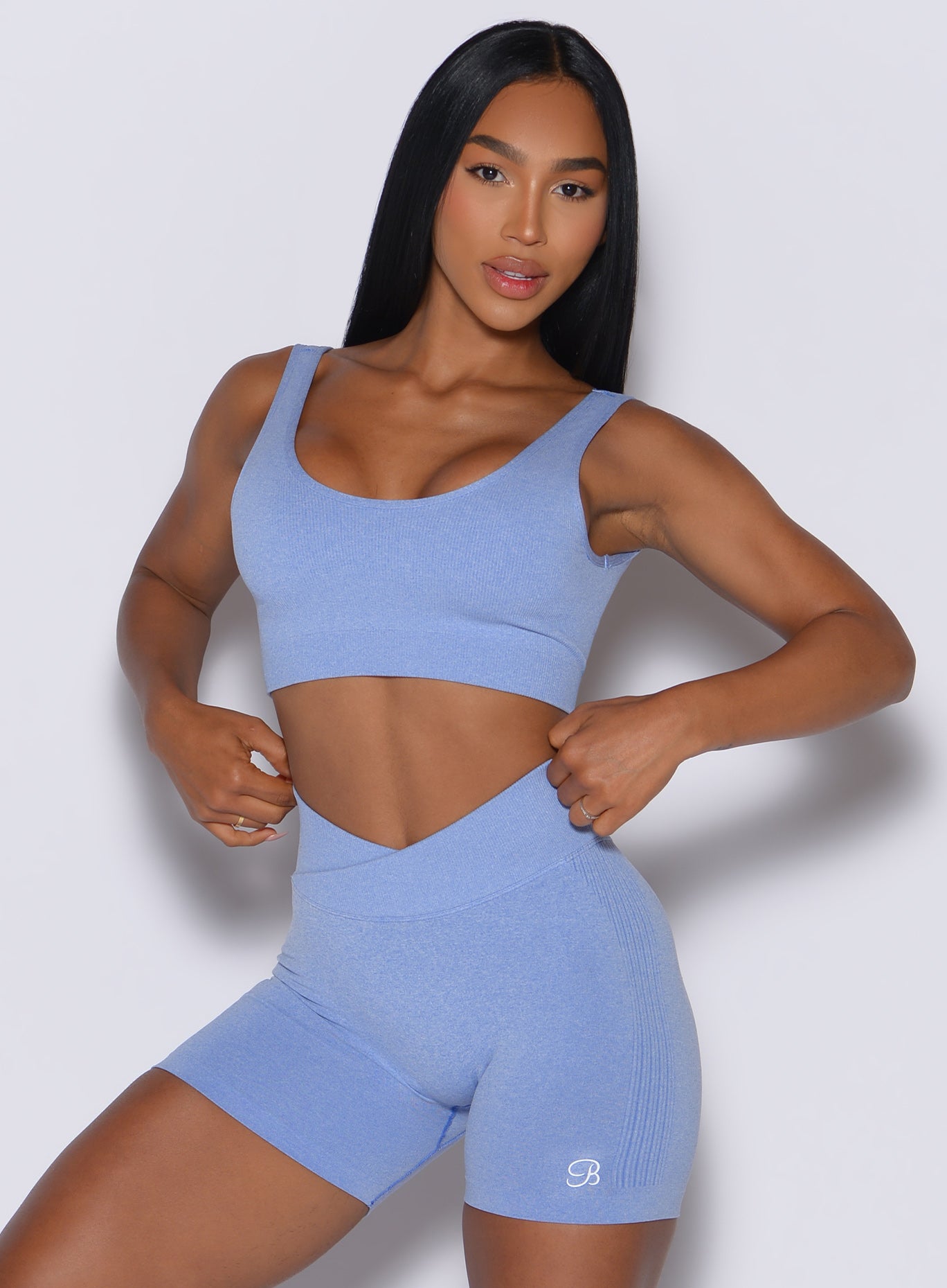 front profile view of a model wearing our Seamless Scoop Bra and the matching shorts in Sky color