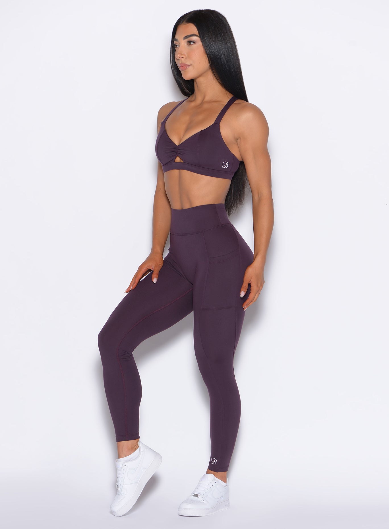 Left side profile view of our model wearing the Define Leggings in Plum Noir color