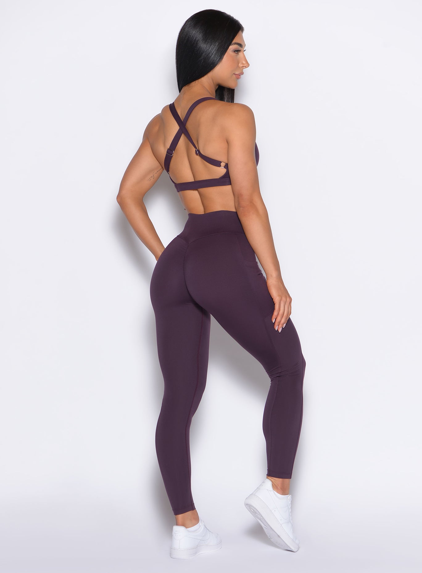 Back right side profile view of our model wearing the Define Leggings in Plum Noir color