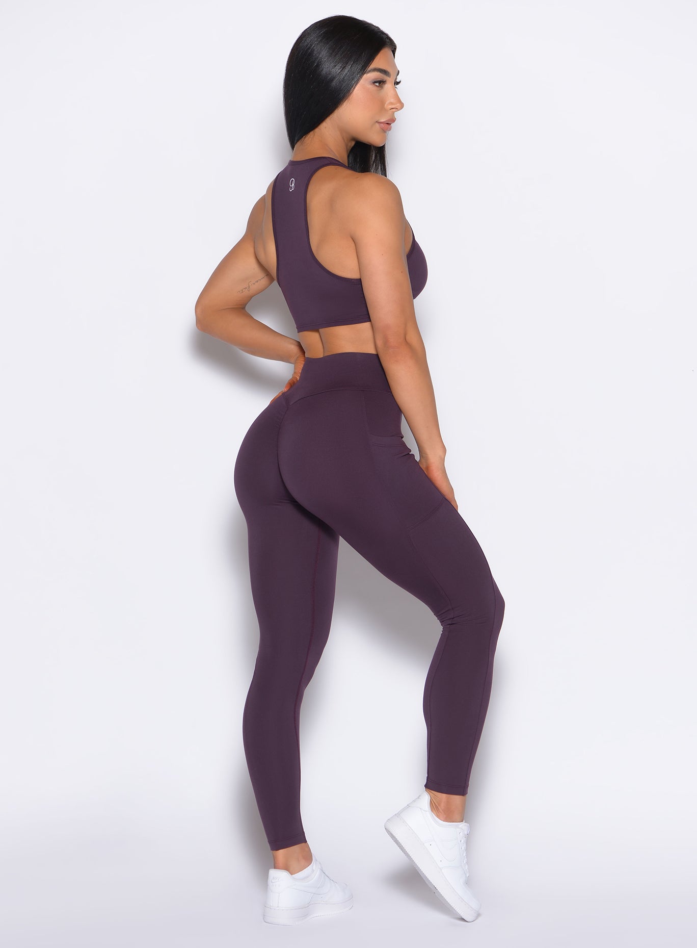 Right side profile view of our model wearing the Define Leggings in Plum Noir color