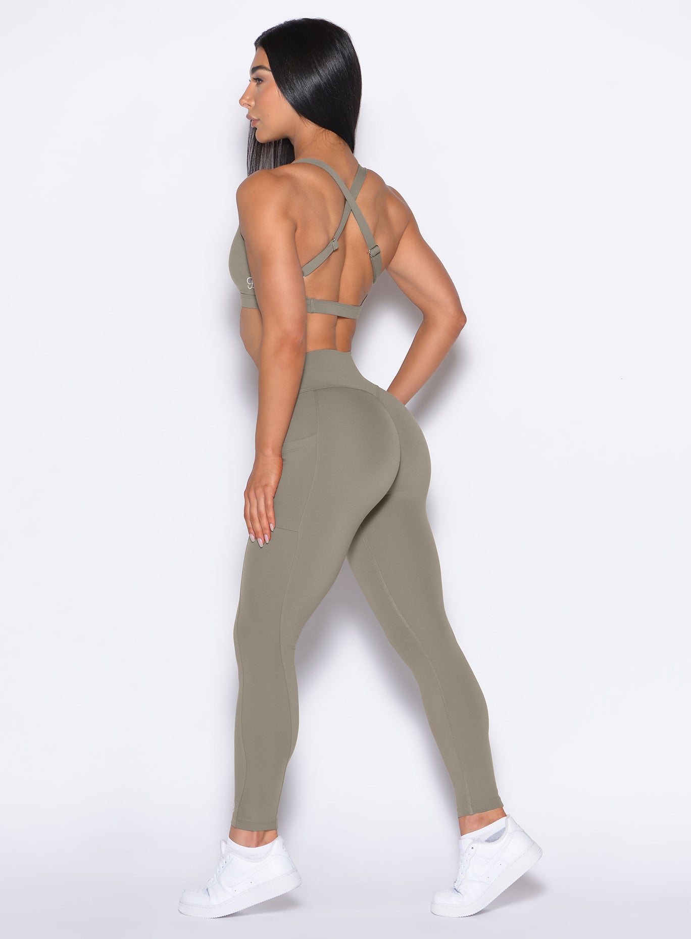 Left side profile view of our model wearing the Define Leggings in Stone color