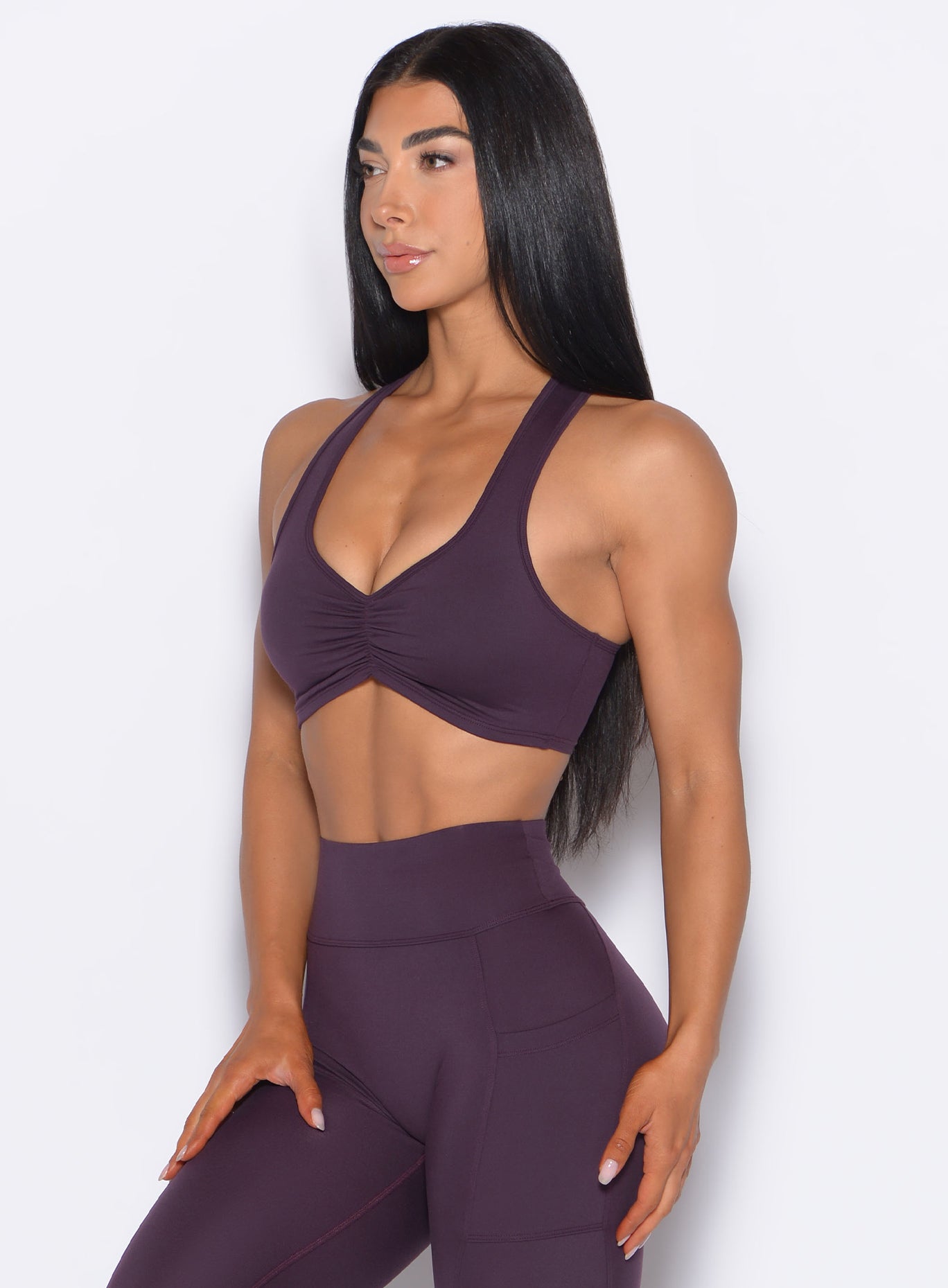 Front left side profile view of our model wearing the Scrunch Tank Bra in Plum Noir color