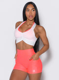 front profile view of a model wearing our white Butterfly Rib Tank on the top of a pink sports bra 