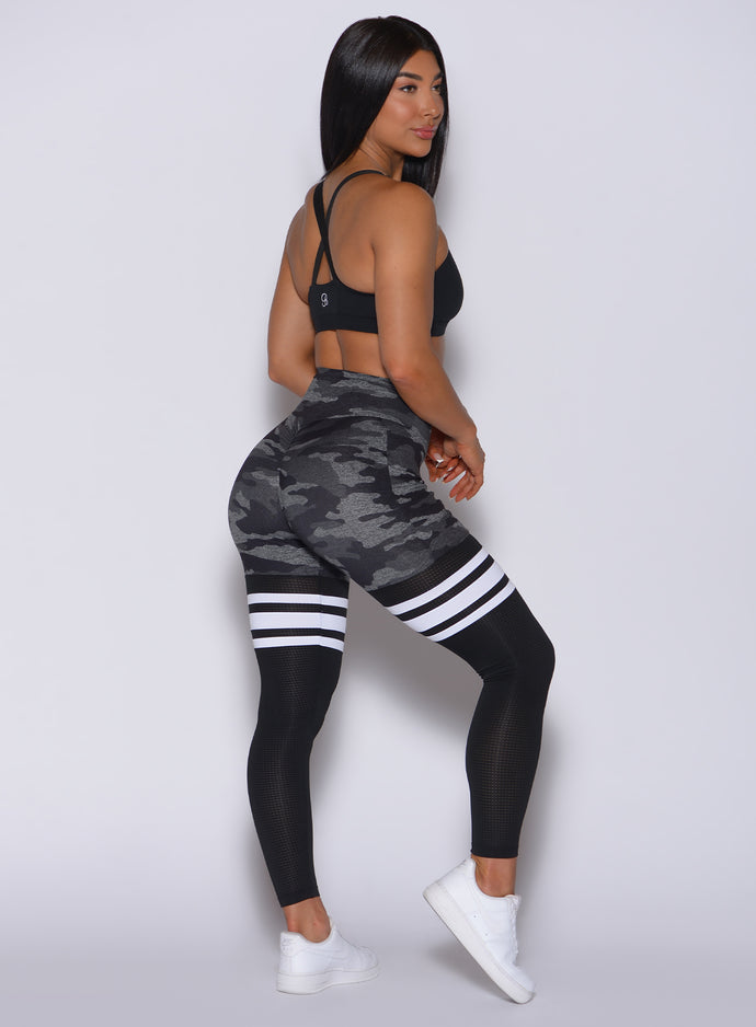 Right side view of model wearing our Scrunch Thigh High in Gray/Black Camo color along with the match black bra