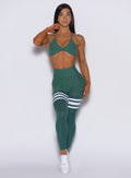 Front profile view of a model wearing our scrunch thigh high in Emerald Green along with a matching bra 