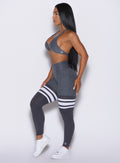 left side profile view of a model facing forward wearing our Scrunch Thigh-Highs and the matching bra in Shadow color
