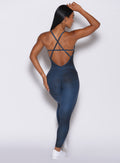 Back profile view of a model in our Sculpt Bodysuit in Vintage blue color