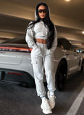 Model standing behind a car with glasses on wearing the Sweat Joggers in Light Heather grey color 