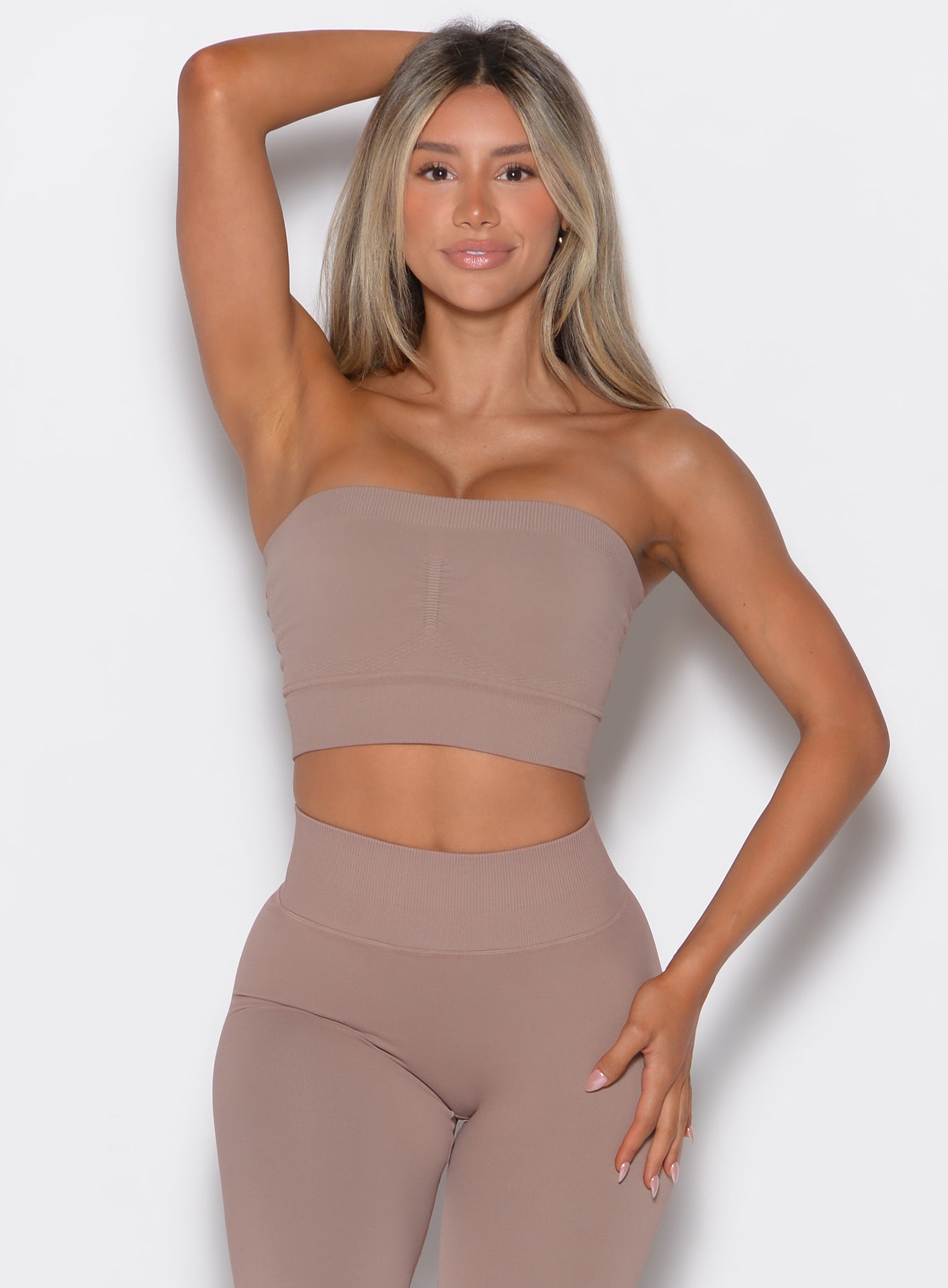 front profile view of a model wearing our seamless bandeau in soft mocha along with the matching leggings