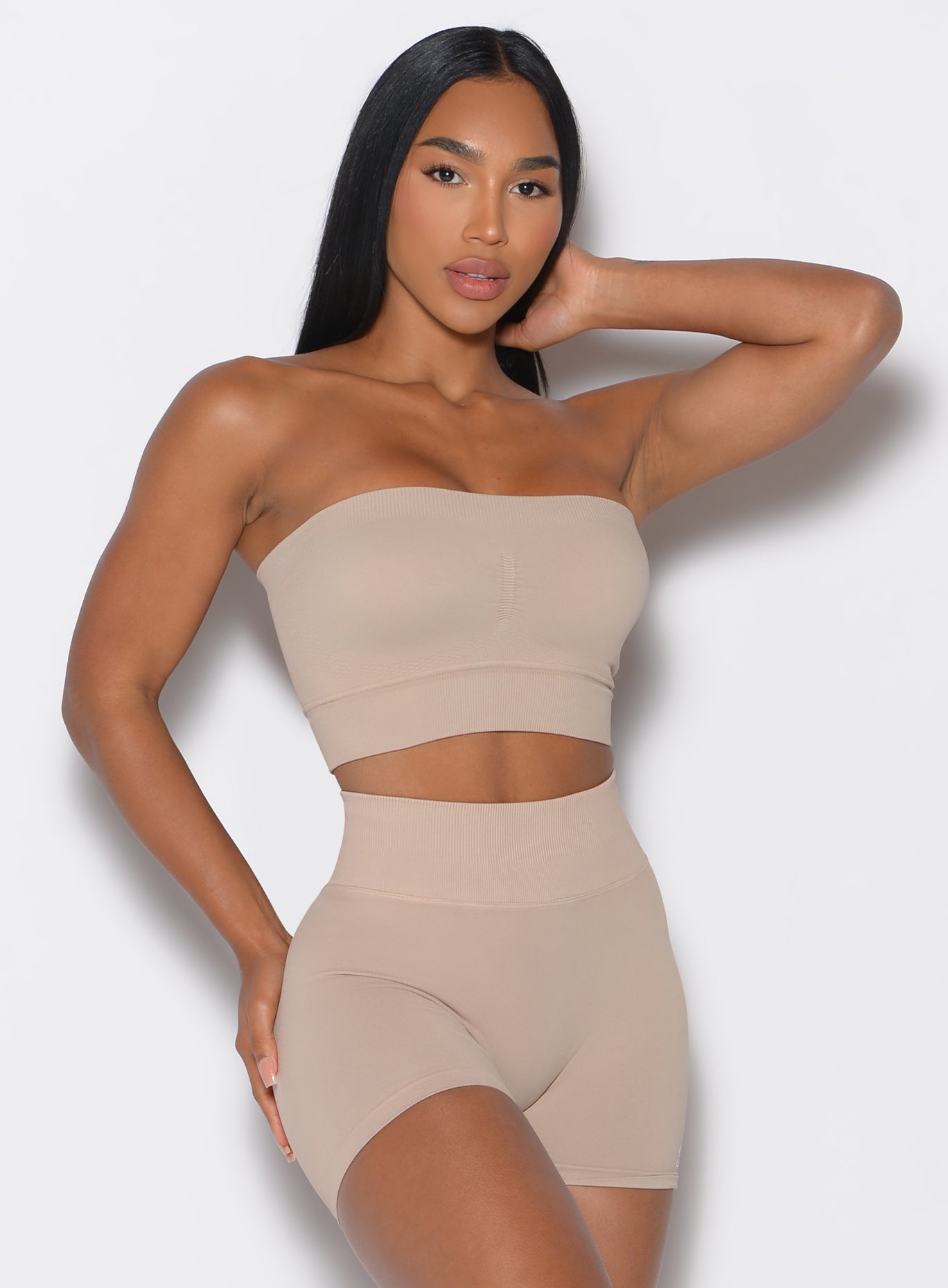 front profile view of a model wearing our seamless bandeau in timeless taupe color along with the matching seamless  shorts