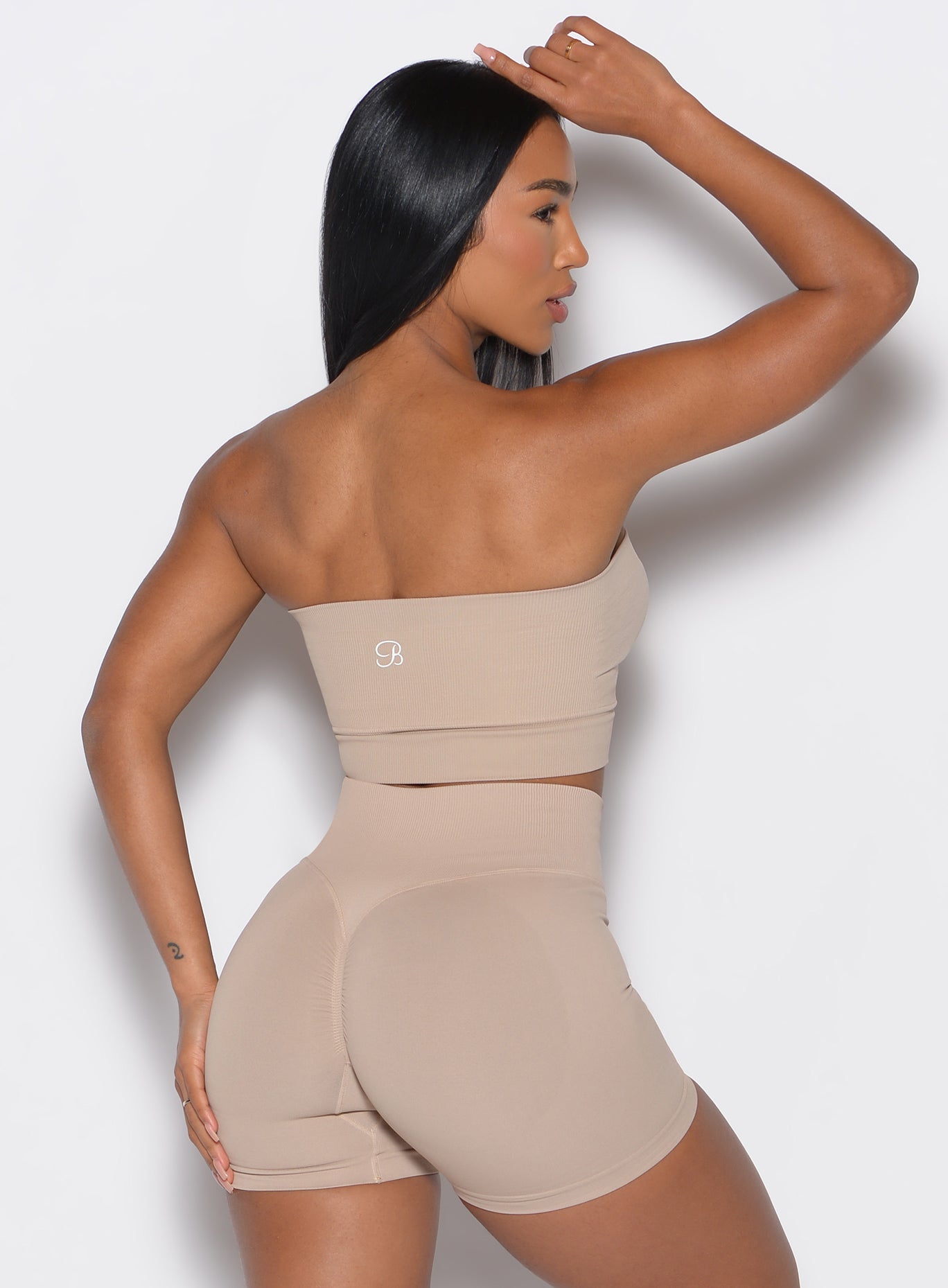 back profile view of a model wearing our seamless bandeau in timeless taupe color along with the matching shorts