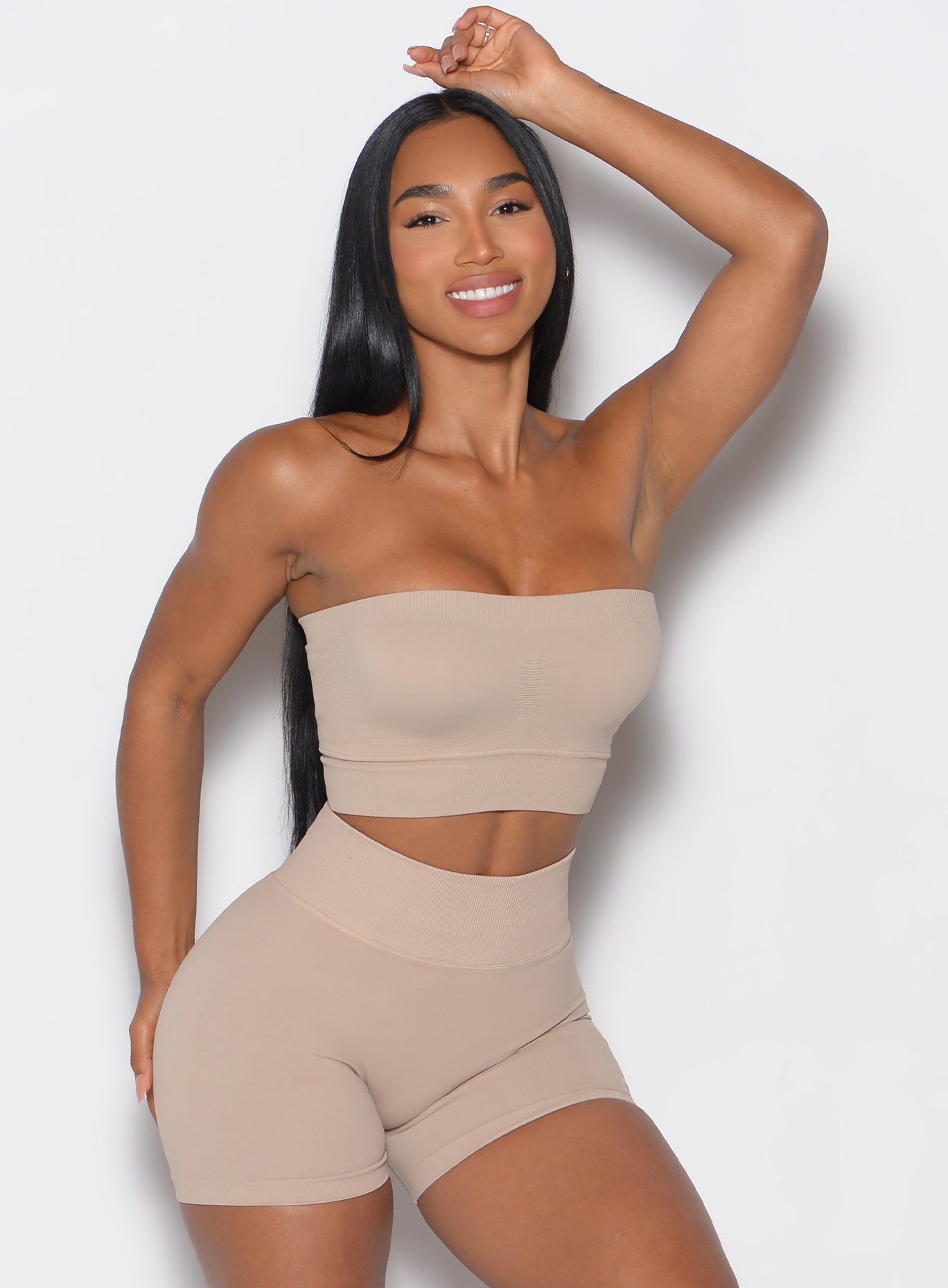 front profile view of a model wearing our seamless bandeau in timeless taupe color along with the matching seamless shorts