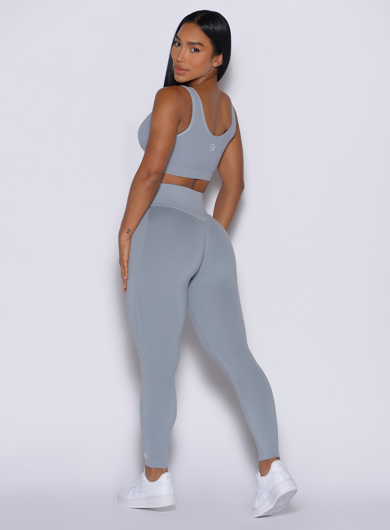 Back left side profile view of our model wearing the Figure Leggings in Carbon color