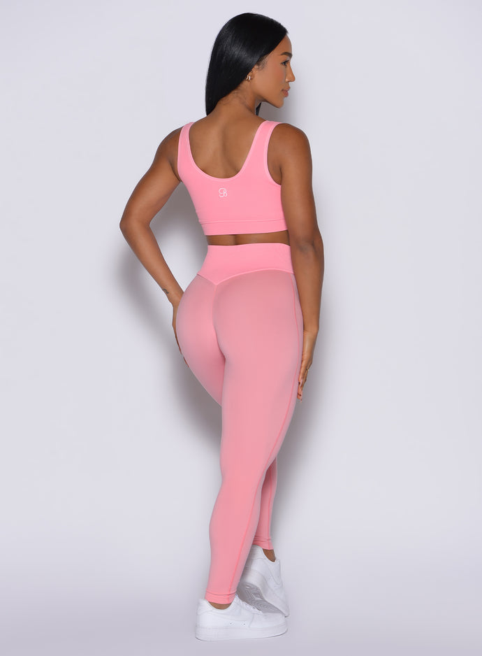 Back profile view of our model wearing the Figure Leggings in Peach Burst color