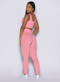 Left side profile view of our model wearing the Figure Leggings in Peach Burst color