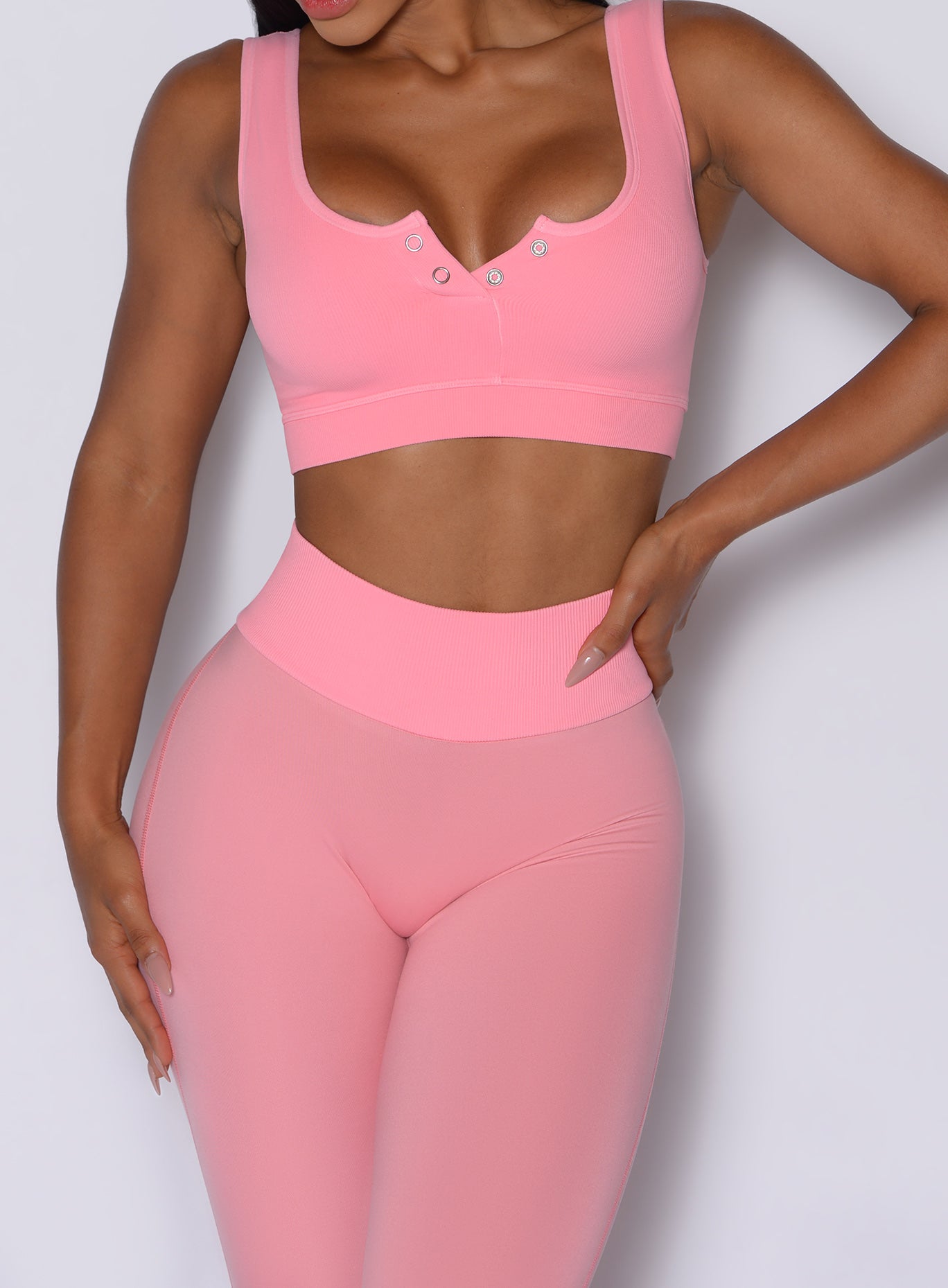 Close up front profile view of our model wearing the Figure Leggings in Peach Burst color