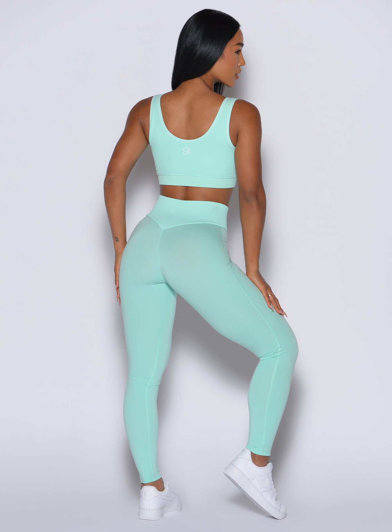 Back profile shot of our model facing to the right wearing the Figure Leggings in Spring Mint color