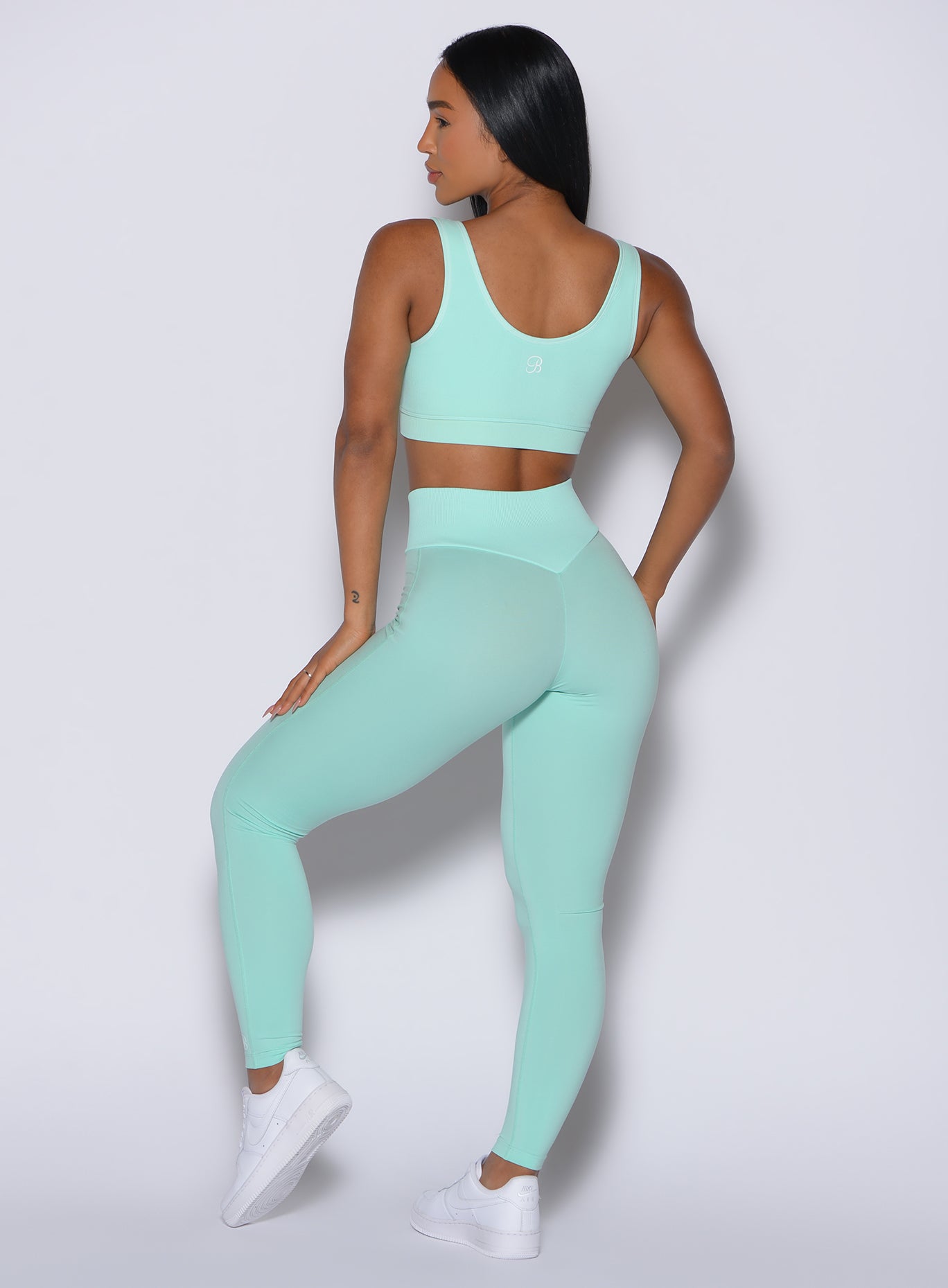 Back profile view of our model wearing the Figure Leggings in Spring Mint color