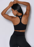 Close up back profile view of our model wearing the Figure Scrunch Leggings in Black color paired with the matching top. 