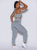 Left side profile view of our model looking over her shoulder wearing the Figure Scrunch Leggings in Carbon color