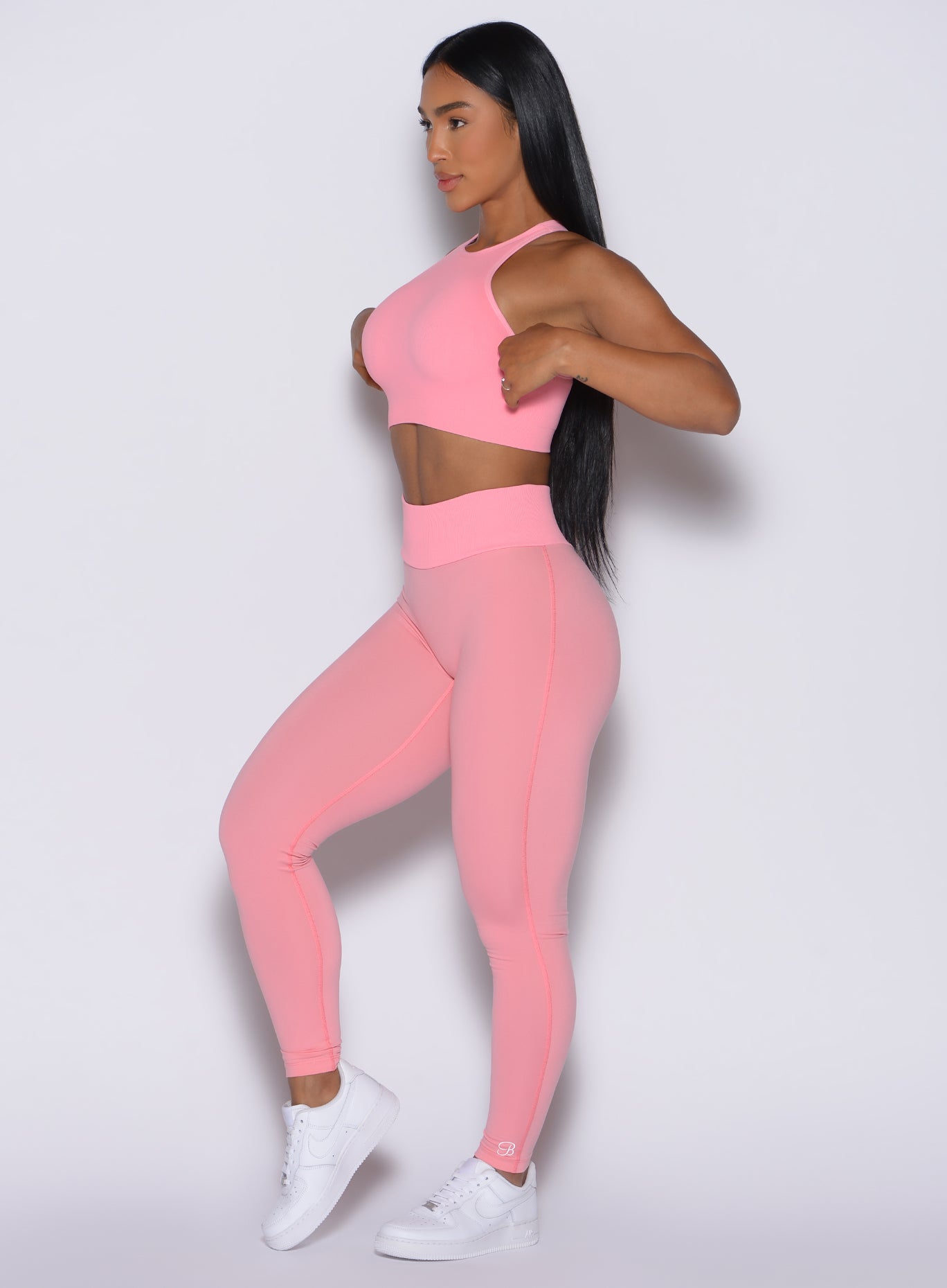 Left side profile view of our model wearing the Figure Scrunch Leggings in Peach Burst color