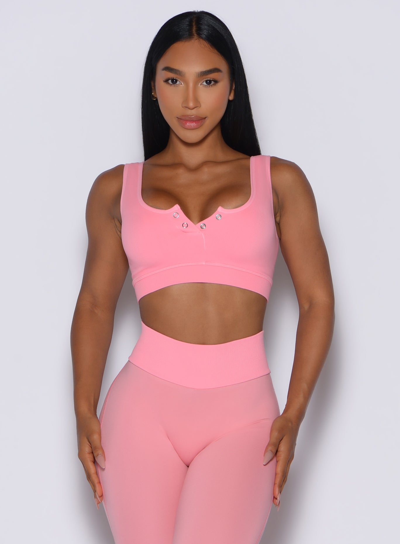 Model facing forward wearing our Snap Seamless Bra and the matching leggings in Peach Burst color