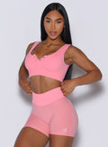 front profile view of a model posing in our Snap Seamless Bra and the matching shorts in Peach Burst color