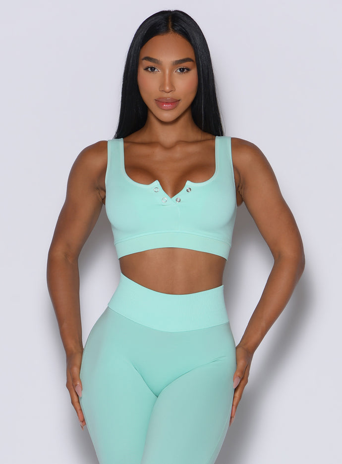 Model facing forward wearing our Snap Seamless Bra and the matching leggings in Spring Mint color