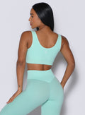 back profile of a model facing to her left wearing our Snap Seamless Bra and the matching leggings in Spring Mint color