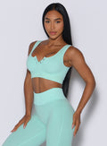 front profile picture of a model angled slightly to her right in our Snap Seamless Bra and the matching leggings in Spring Mint color