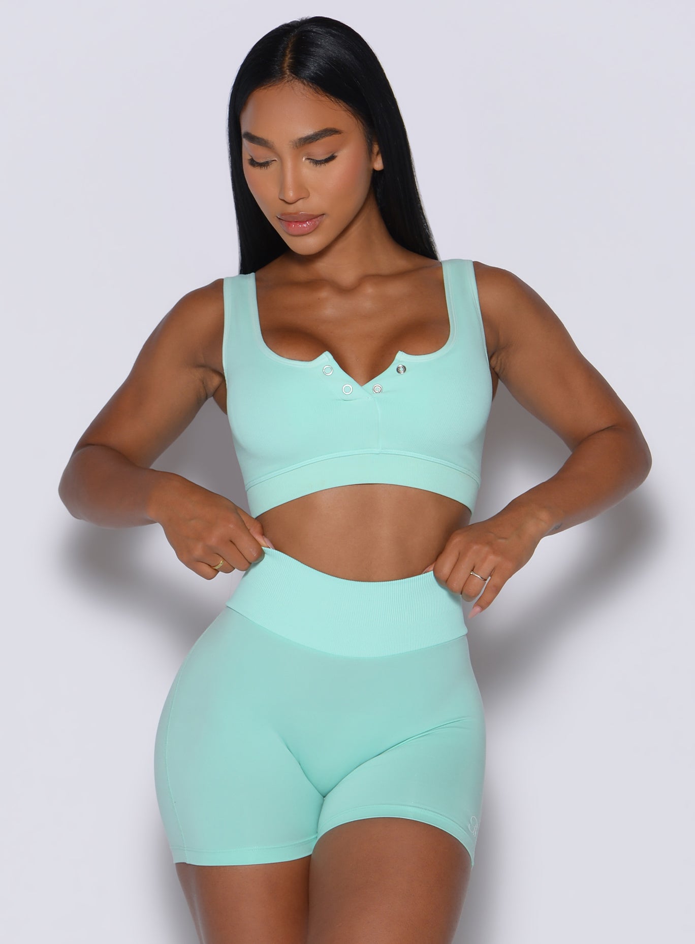 front profile view of a model wearing our Snap Seamless Bra and the matching shorts in Spring Mint color