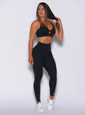 Front profile view of a model in our new and enhanced black shape leggings and a matching bra 