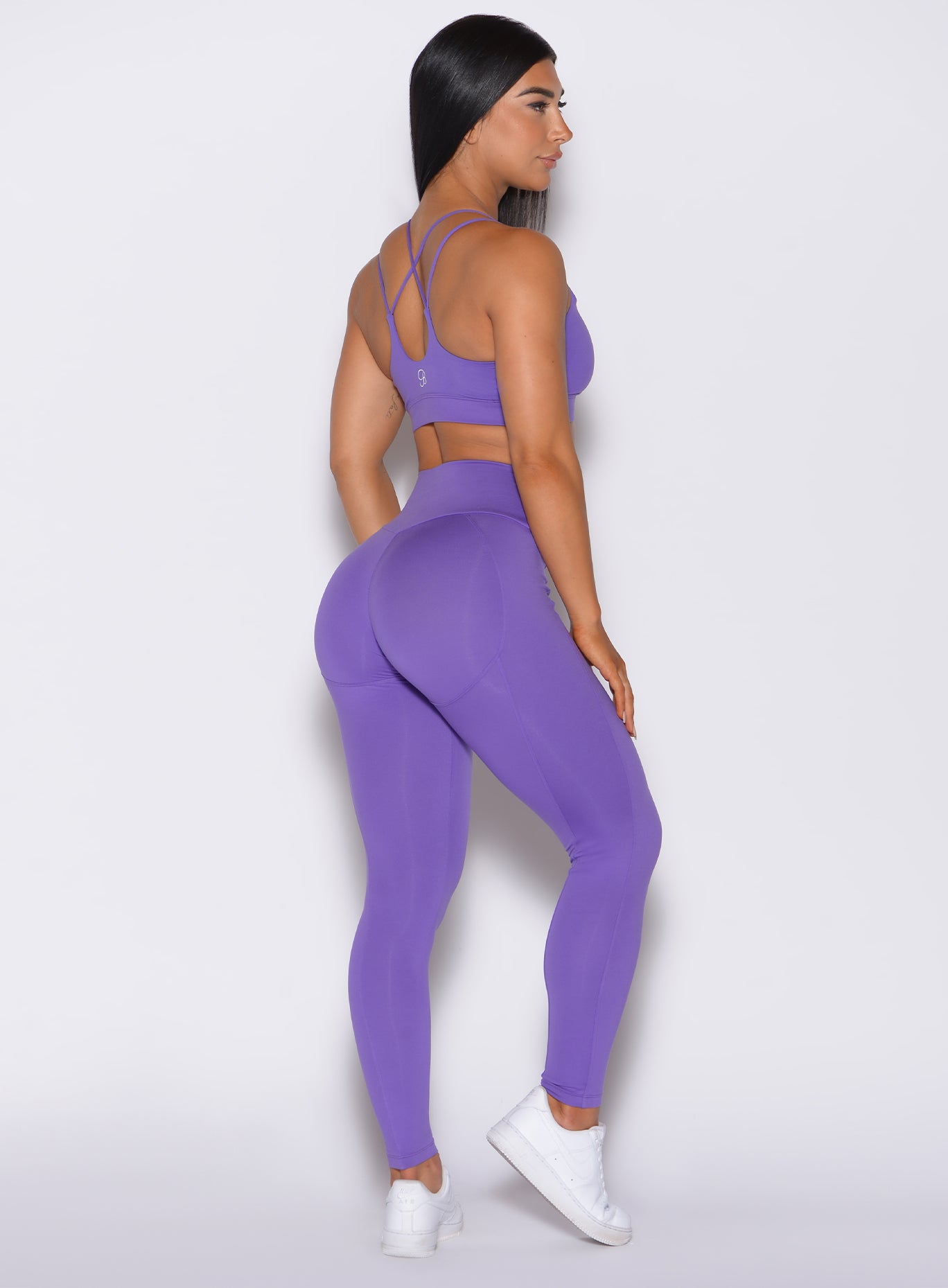 Right side profile view of a model wearing our shape leggings in royal purple color along with the matching bra